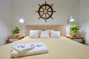 A hotel room with a bed, a ship's wheel decoration, two bedside tables with lamps, and two potted plants. - Holiday Home With Private Lake and Beach (Bytow)
