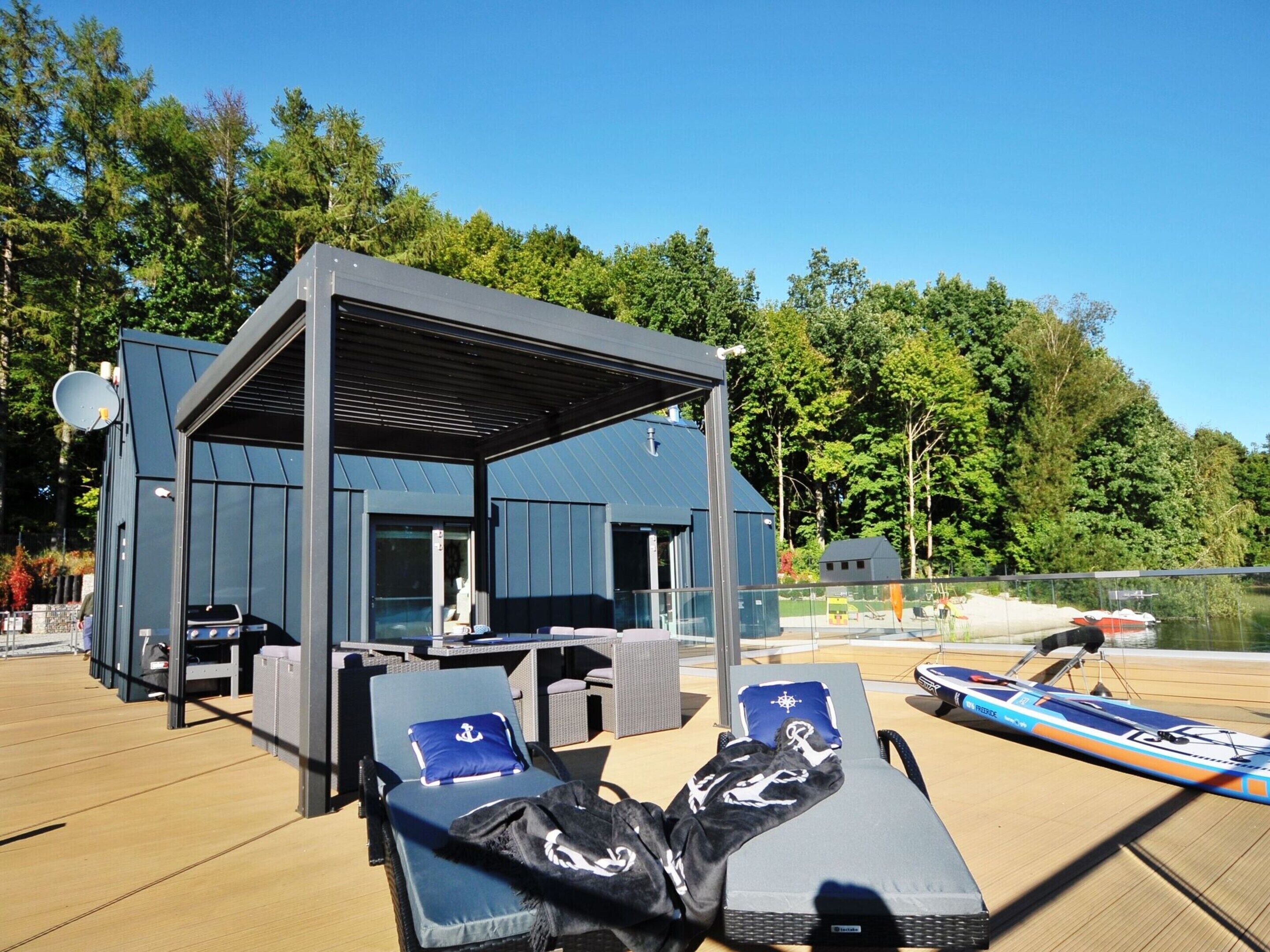 A covered outdoor area with lounge chairs and a boat.