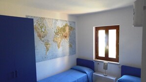 A room with two beds, a world map on the wall, and a window with blinds. - Apartment for 6 People, Cannigione (Arzachena)