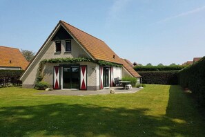 A single-story house with a sloped roof, a front porch, and a well-maintained lawn.
