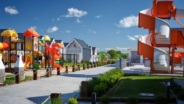 A playground with various play structures and a pathway leading to a building. - Holiday Homes With Pool, Attractions for Children (Mielno)