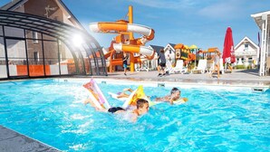 A swimming pool with people using inflatable floats. - Holiday Homes With Pool, Attractions for Children (Mielno)