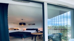 A modern bedroom with a bed, bedside tables, and a small table with chairs.