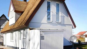 A traditional house with a steeply pitched roof, white exterior walls, and a small attached garage. - Ferienhaus, Boiensdorf (Boiensdorf)