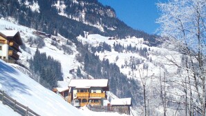 A mountain lodge with a wooden facade, surrounded by snow-covered trees and a backdrop of mountains. - Chalet in Grossarltal With Panoramic Views (Grossarl)