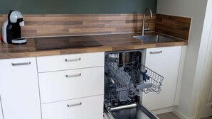 A kitchen with a dishwasher, a coffee maker, and a wooden countertop. - Historic Cottage w/ Garden (Breskens)