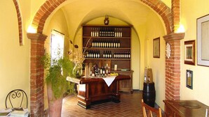 Eine Bar mit einer Ziegelbogenarchitektur, einer Holztresen und einem Weinkühlschrank voller Flaschen.