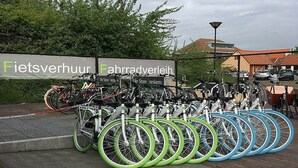 A bicycle parking area with multiple bicycles and a sign that reads 'Fietsverhuur' and 'Fahrradverein'. - Pet-Friendly Coastal Home (Breskens)