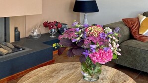 Ein Wohnzimmer mit rundem Couchtisch, einer Couch, einem Kamin und einer Lampe.