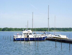 Barco atracado com uma cabine e um veleiro menor amarrado ao lado.