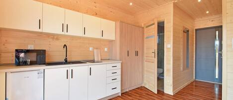 Una cocina moderna con armarios de madera, un microondas y un lavamanos.