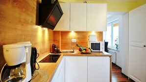 A compact kitchen with a coffee maker, microwave, and sink. - Comfortable 3-room Apartment Close to the sea (Ustronie Morskie)
