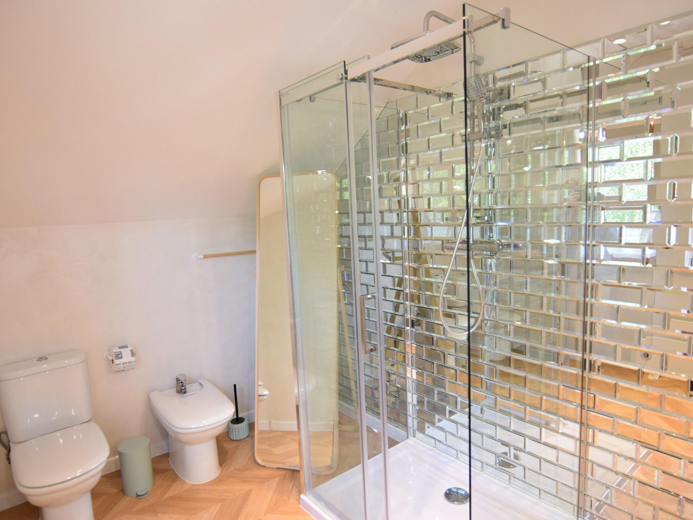Ein modernes Badezimmer mit Duschkabine aus Glas, Toilette und Bidet.