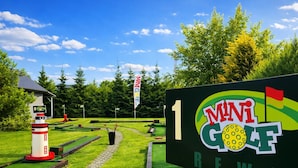 Pienen golfkentän opastekyltti, jossa on numero ’1’ ja sanat ’MINI GOLF’ ja ’REWI  ’.