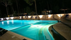 A swimming pool with lounge chairs and umbrellas. - Apartment in Pietra Ligure (Pietra Ligure)