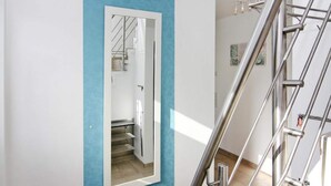 A modern interior with a blue accent wall, a metal staircase, and a door leading to a stairwell.