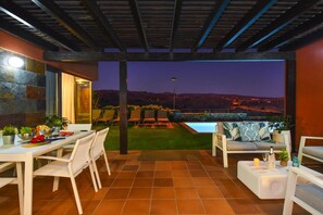An outdoor patio with a dining table, chairs, and a pool. - Holiday Home, Maspalomas (San Bartolomé de Tirajana)