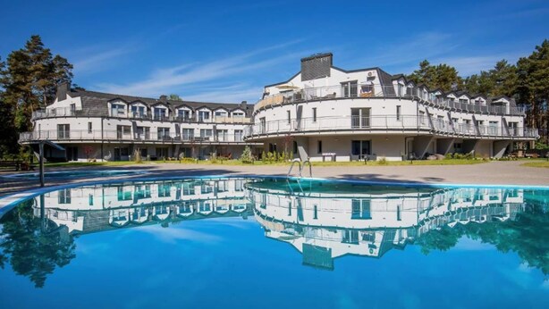 A hotel with a large swimming pool and a reflection of the building. - Apartment With Swimming Pool, Terrace, Pobierowo (Rewal)