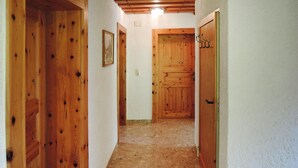 A narrow hallway with wooden doors and a framed picture on the wall. - Apartment in Fusch Near Grossglockner Road (Fusch an der Grossglocknerstrasse)