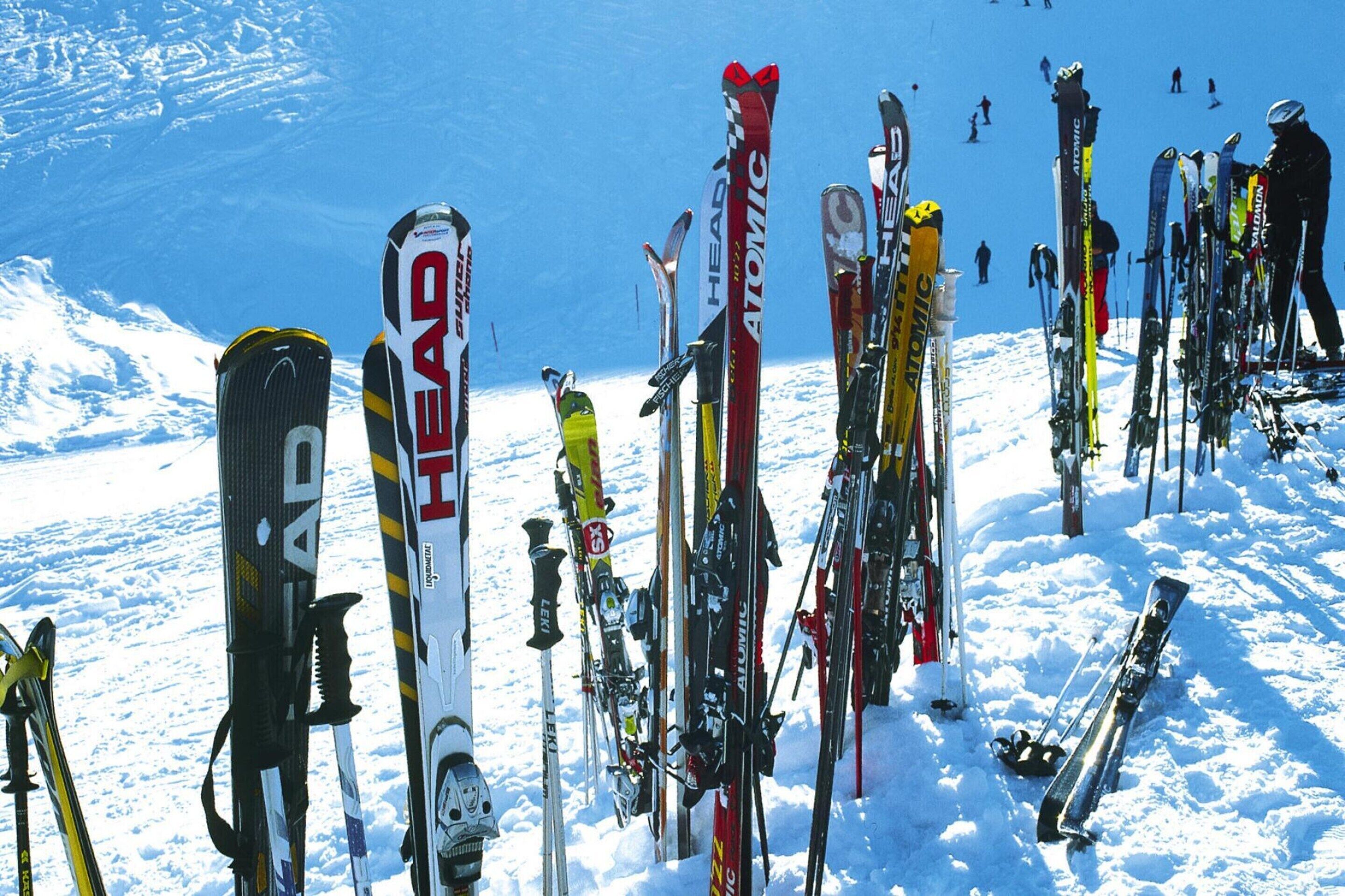 A collection of skis lined up on a snowy slope.