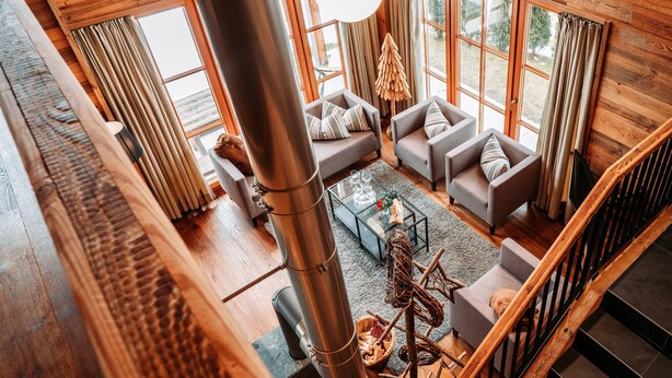 A high-ceilinged room with a large metal column, wooden walls, and a staircase. - Chalet in Leutasch Near Kreithlift Ski Resort (Leutasch)