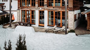A two-story log cabin with large windows and a covered patio area. - Chalet in Leutasch Near Kreithlift Ski Resort (Leutasch)