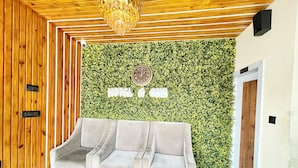 A reception area with a green wall, a clock, and a three-seater sofa. - A One Pride - Puri near Sea Beach (Puri)