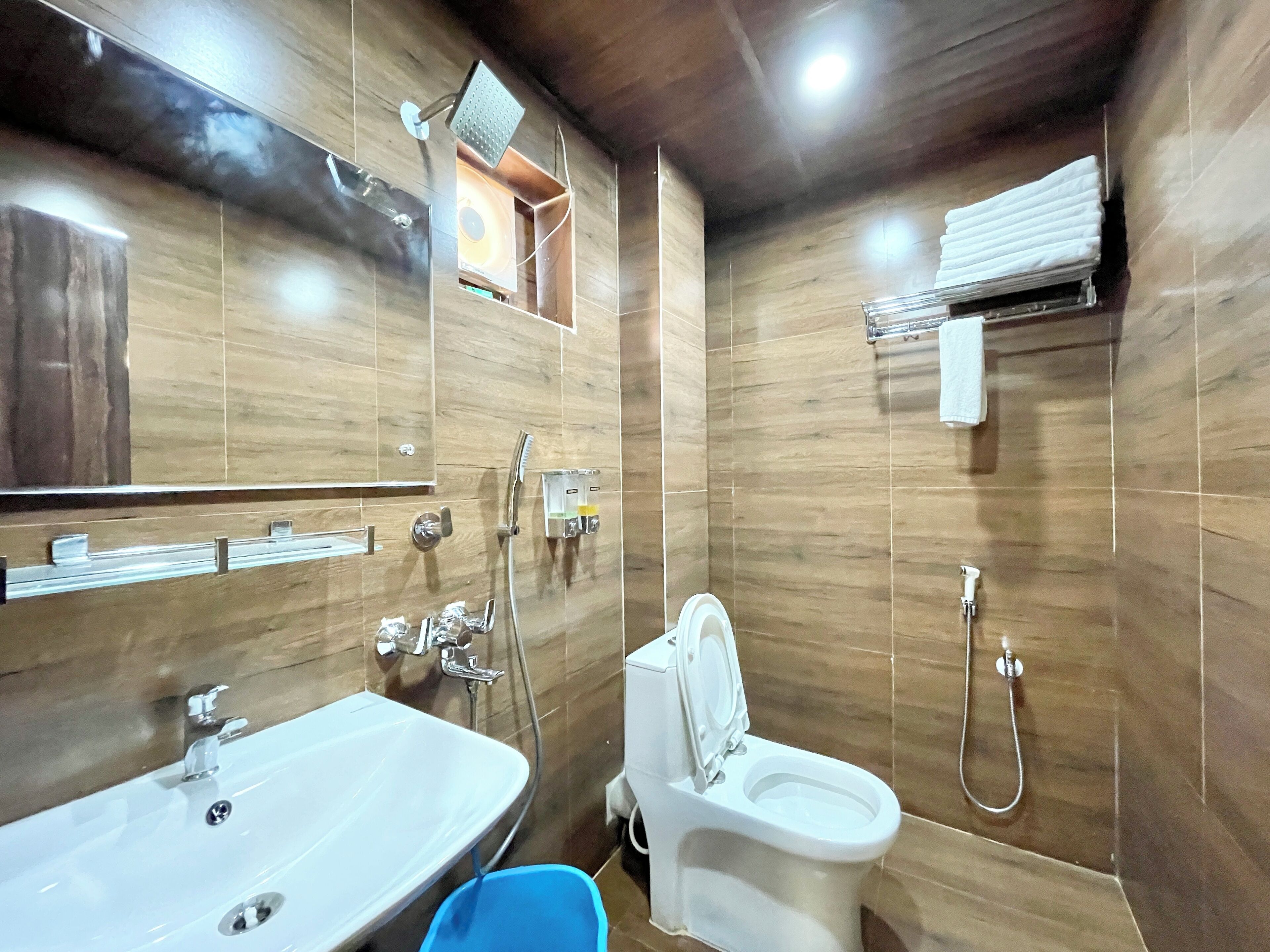 Un baño con lavamanos, inodoro, ducha y espejo.