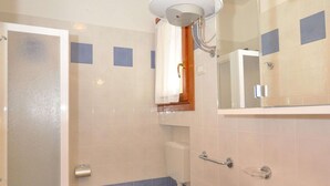 A bathroom with a toilet, sink, and shower.