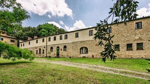 Ein Innenhof mit einem Steinhaus, das mehrere Fenster und Bögen zeigt.