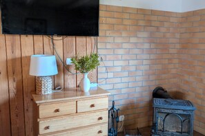 A wooden dresser with drawers, a lamp, and a vase with a plant. - Holiday Home With Jacuzzi and Private Garden (Gizycko)