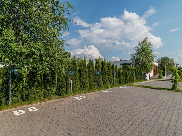 A parking area with marked spaces and a building labeled "ROSENHAUS" in the background.