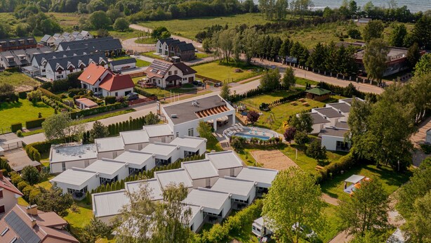 A residential area with modern houses, a swimming pool, and a view of the sea. - Holiday Homes With Pool, Close to the Beach (Ustronie Morskie)