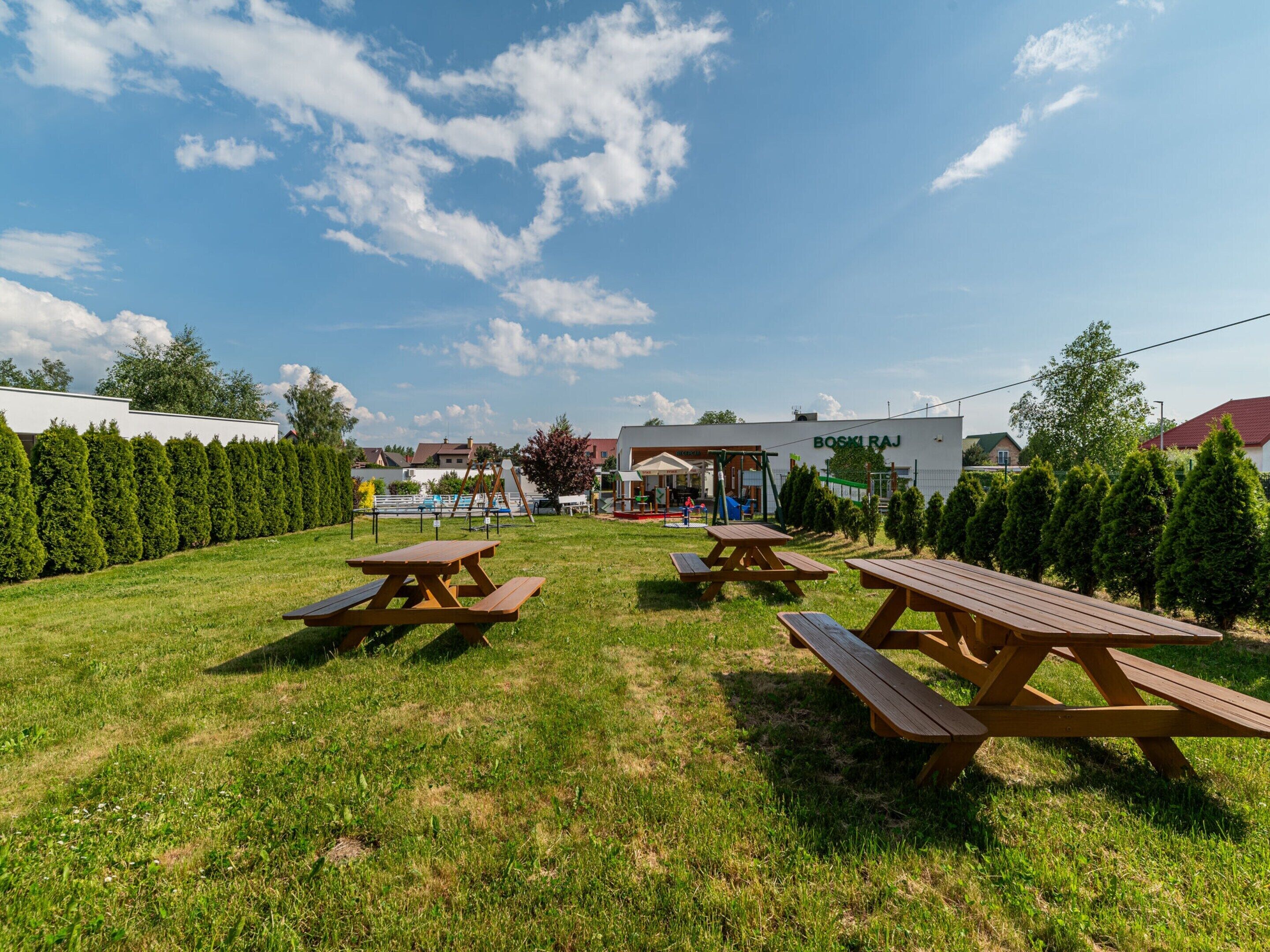 An outdoor area with picnic tables and a playground.