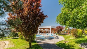 A pathway leading to a building with outdoor seating and a pool area. - Holiday Homes With Pool, Close to the Beach (Ustronie Morskie)