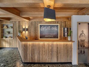 A wooden reception desk with a chalkboard sign reading "GriaB enk" and "Art Resort Fugenhof Almendorf Zillertal". - Apartment in Fugen Near Spieljochbahn (Fuegen)