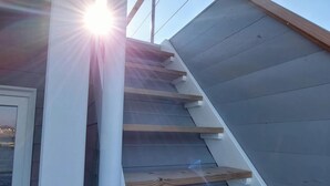 A staircase with wooden steps and white railings leading to a door. - Houseboat Hecht in Egernsund at the Marina Minde (Broager)