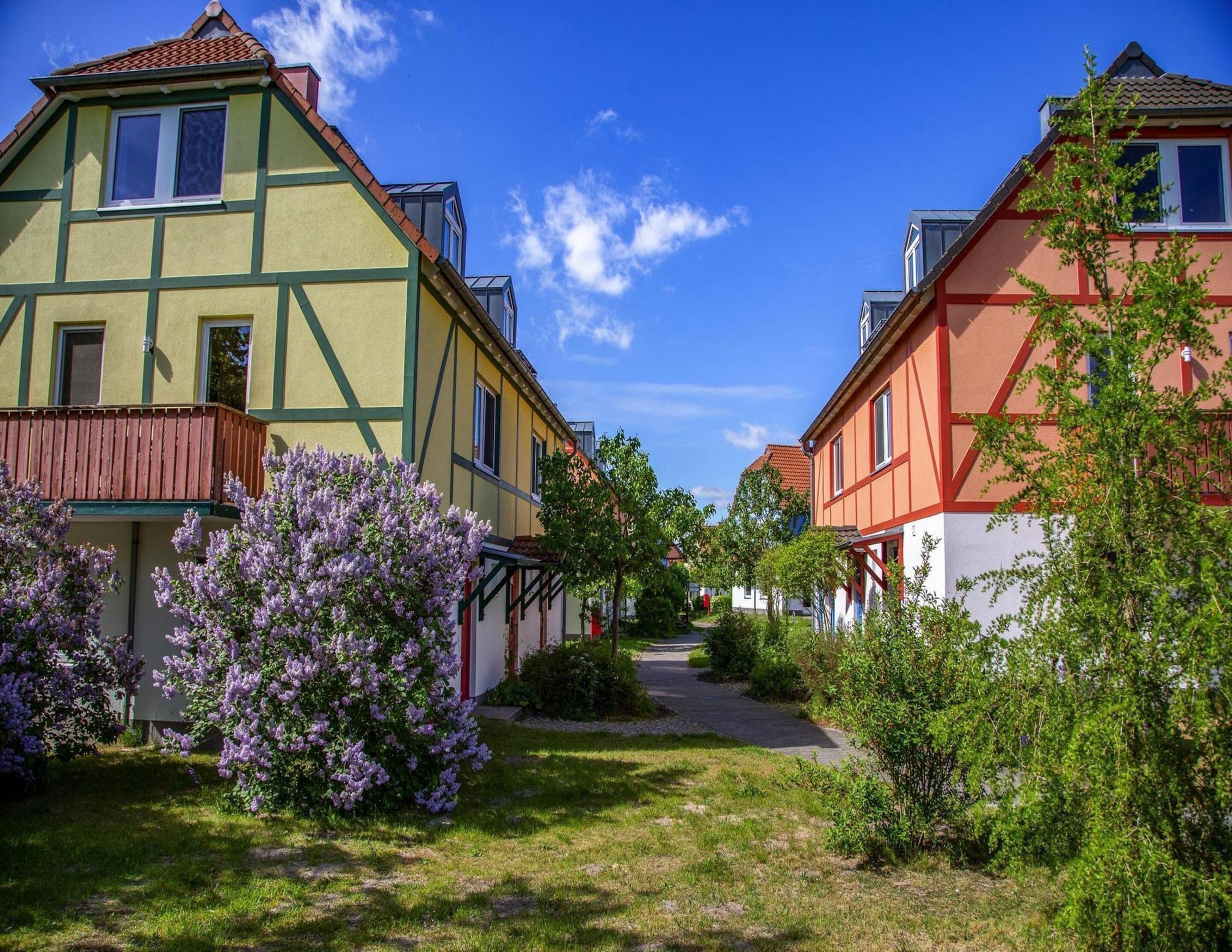 A row of traditional European-style houses with a narrow pathway between them.