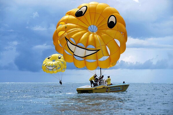 A boat with two parachutes, one with a face and another with a smile, on the water. - Coastal Apartment for Romantic Getaway (Vir)