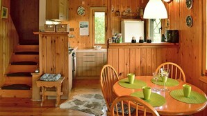 Ein gemütliches Holzhaus-Interieur mit Essbereich, Küche und einer Treppe.