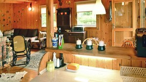 Ein Holzblockhaus mit Wohnzimmer, Küche und Essbereich.