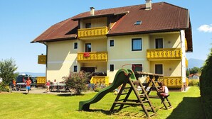 A two-story building with a red-tiled roof and yellow balconies. - Sunny Holiday Apartment With Balcony on Klopeinersee With Private Beach (Sankt Kanzian am Klopeiner See)