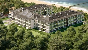 A modern multi-story hotel with a rooftop terrace, located near a beach with a pier. - Beautiful Apartment Very Close to the Beach (Rewal)