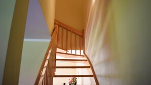 Un escalier en bois, doté d’une rampe, menant à l’étage supérieur.