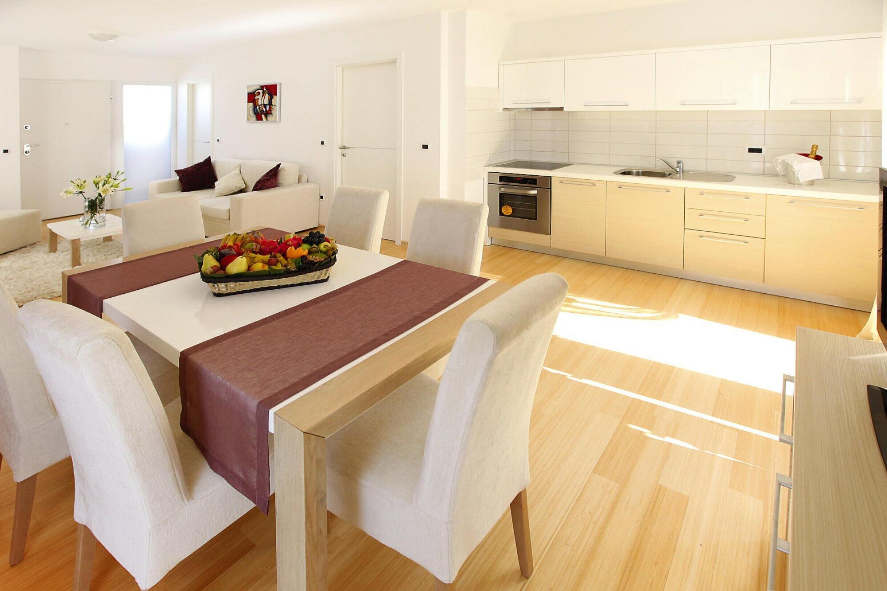 Een moderne keuken met witte kastjes, een roestvrijstalen spoelbak en een inbouwoven.
