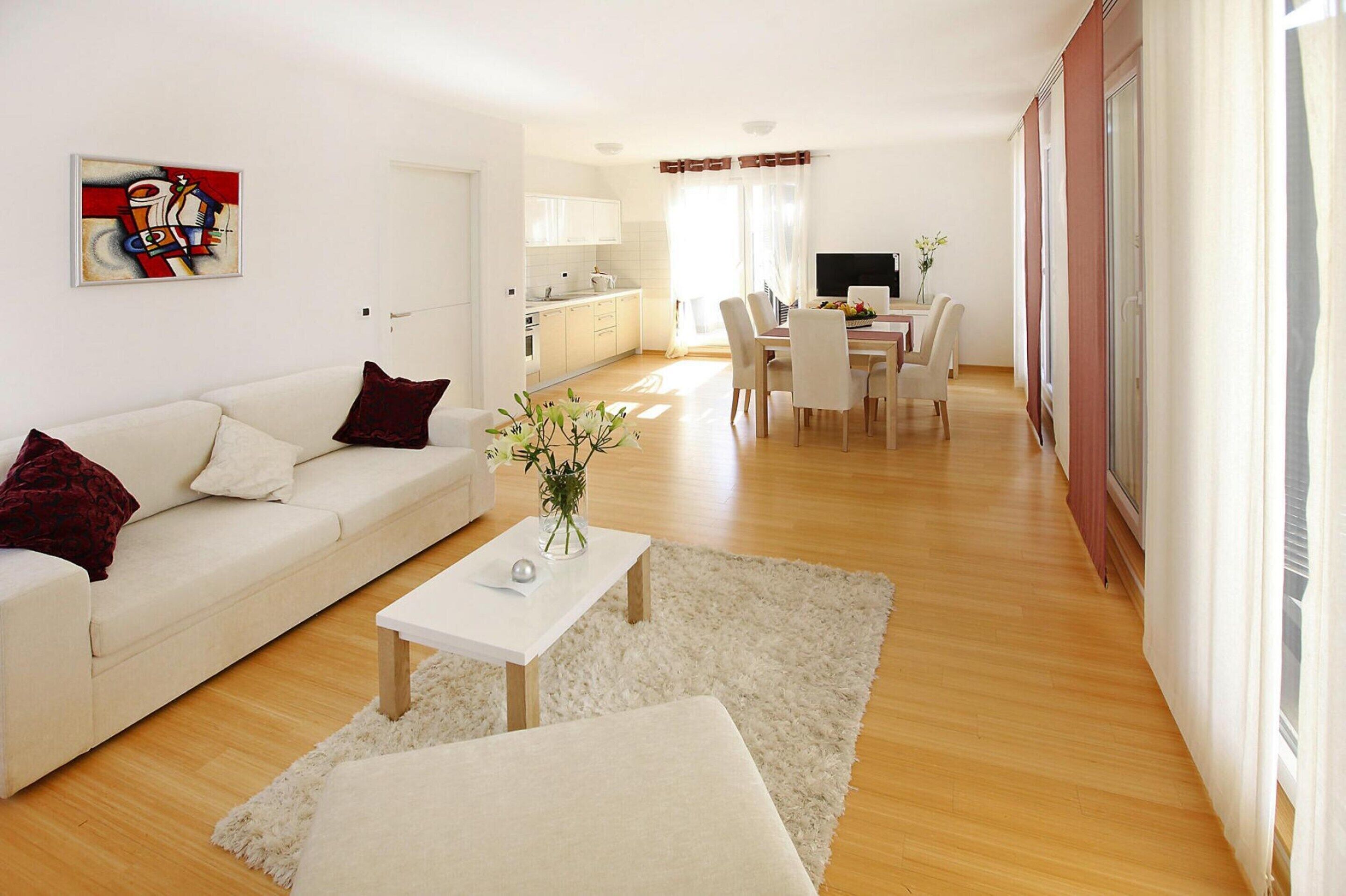 Un salon moderne comprenant un canapé, une table basse et un coin repas avec des chaises et une table.