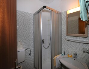 Une salle de bain avec une douche à parois de verre, un lavabo, des toilettes et un miroir.
