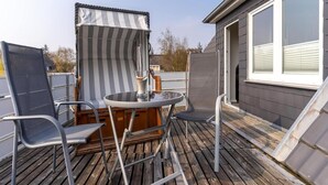 En terrasse med et bord, stole og et iøjnefaldende markise.