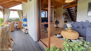 A cozy living area with wicker furniture, a blue sofa, and a wicker coffee table. - Holiday Home in Mielno Near Beach & Lake (Mielno)