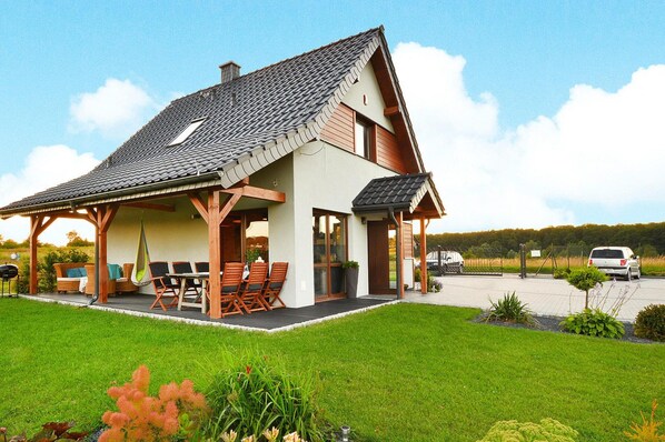 Relax on the covered patio with a dining table and chairs, and a hanging chair for unwinding.